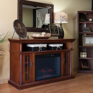 A cozy living room setup featuring a wooden fireplace console with decorative items, a large mirror above, and a bookshelf on the side.