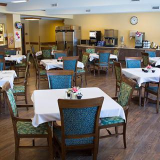 An empty dining room with tables and chairs neatly arranged.