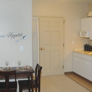 A cozy apartment kitchen and dining area with a small table set for two.
