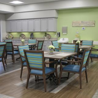 A modern dining room with colorful chairs and tables, featuring a bright and inviting atmosphere.