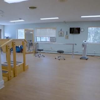 A spacious physical therapy room equipped for rehabilitation exercises.