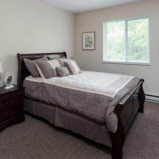A neatly arranged bedroom with a large bed and decorative pillows.