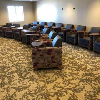 A cozy seating area featuring multiple chairs with side tables, perfect for relaxation or waiting.