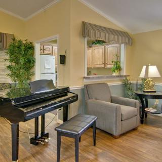A cozy living room with a grand piano and comfortable seating.