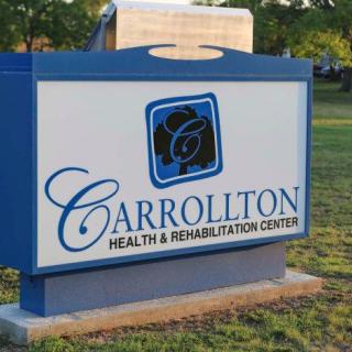 Sign for Carrollton Health & Rehabilitation Center in an outdoor setting.