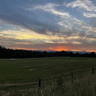 A serene sunset illuminating the sky over a peaceful field.