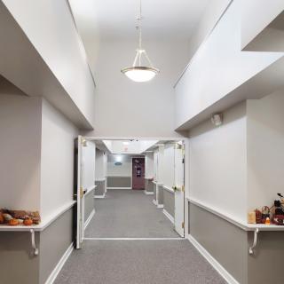 A well-lit interior hallway with open double doors and simple decor.