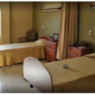A hospital room with two beds and a curtain divider.