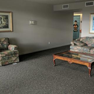A spacious living room featuring two sofas, a coffee table, and a piece of artwork on the wall.
