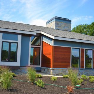 Modern house with large windows and contemporary landscaping.