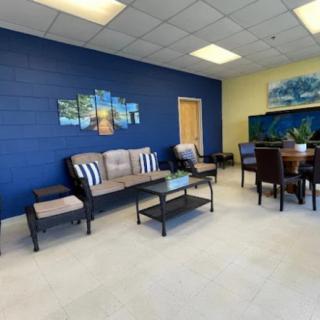 A cozy waiting room with comfortable seating and a vibrant blue accent wall.