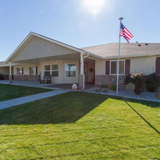A charming residential home with a well-maintained lawn and an American flag waving proudly.