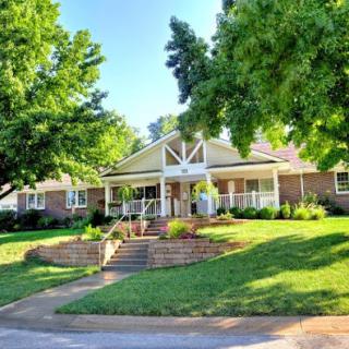 A charming residence featuring well-maintained landscaping and inviting steps leading to the entrance.