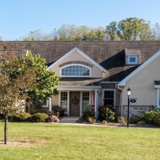 A suburban house with a well-maintained lawn and trees.