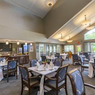 A spacious indoor dining area with set tables and elegant lighting.