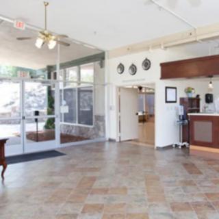 A spacious hotel lobby with a reception desk and large glass entrance.