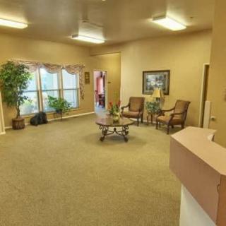 A cozy waiting room with comfortable chairs and decorative plants.
