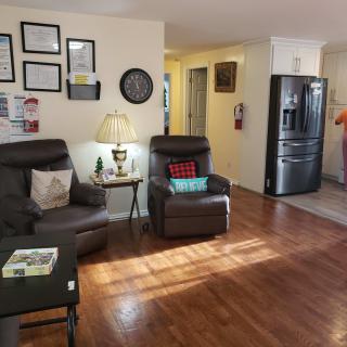 Cozy living room with warm lighting and a glimpse into the kitchen area.