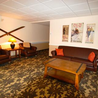 A cozy living room with a sofa, armchairs, and decorative wall art.
