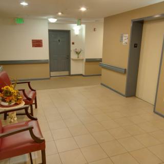 Hospital waiting area featuring seating and an elevator.