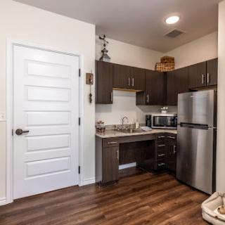 A modern kitchen featuring sleek cabinetry, stainless steel appliances, and a warm wooden floor.