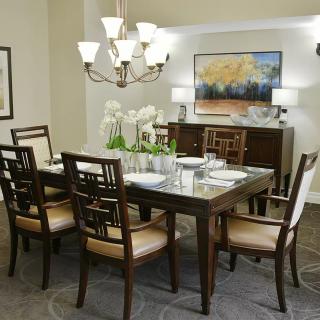 A modern dining room with elegant furniture and a stylish chandelier.