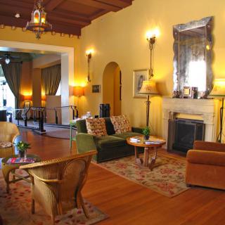A cozy living room featuring warm lighting, elegant furniture, and a decorative fireplace.