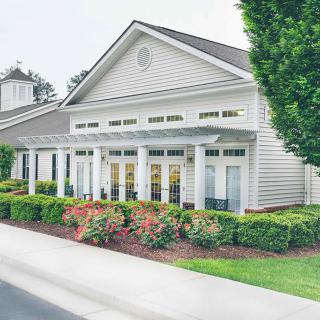 A well-maintained building with classic columns and surrounding landscaped gardens.