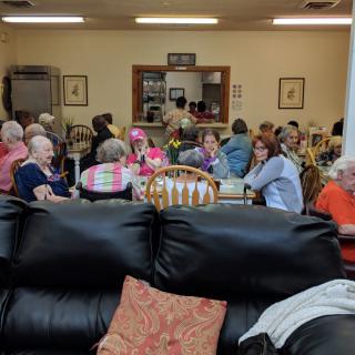 A group of people gathered in a dining area, enjoying a social event.