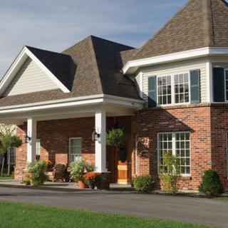 A suburban brick house with a manicured front yard.
