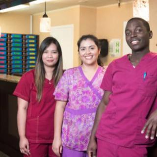 A group of smiling healthcare professionals in their uniforms.