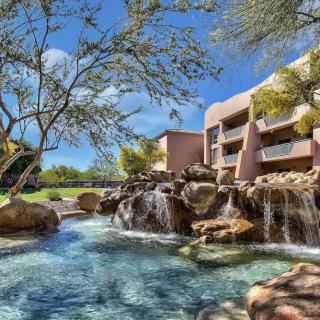 A beautiful resort with a cascading waterfall surrounded by lush greenery.