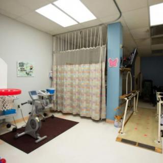 A physical therapy room equipped with exercise equipment and rehabilitation tools.