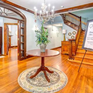A beautifully decorated foyer with a central table, chandelier, and staircase.