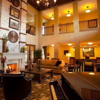 A luxurious hotel lobby featuring elegant furniture, a cozy fireplace, and a grand piano.