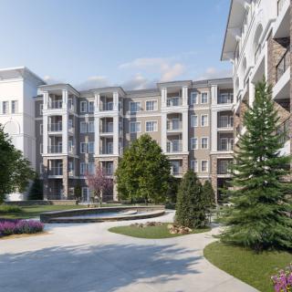 A modern residential complex surrounded by landscaped gardens and greenery.