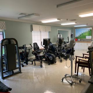 A rehabilitation gym equipped with various exercise machines and therapy tools.