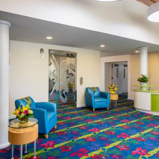 A vibrant and modern lobby area featuring colorful carpet and seating arrangements.