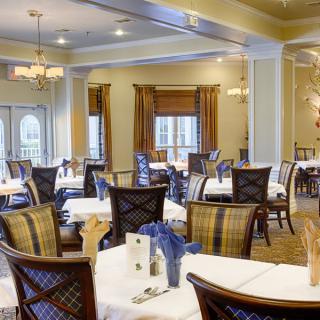 An elegant dining room with neatly arranged tables and chairs.