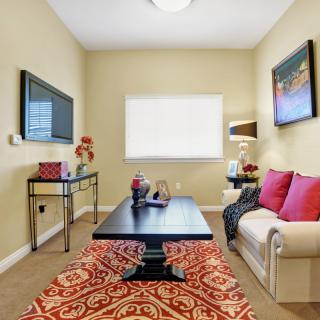 A modern living room with colorful accents, featuring a comfortable sofa, coffee table, and decorative wall art.
