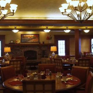 A cozy restaurant dining room with elegant lighting and a fireplace.
