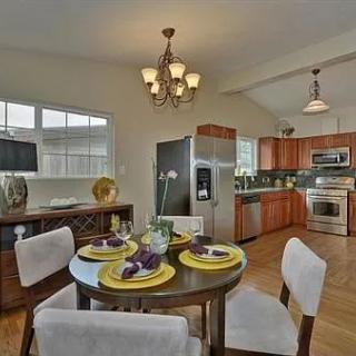 A modern kitchen and dining area with a set table and stainless steel appliances.
