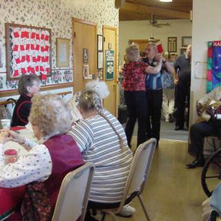 A group of seniors enjoying a social gathering with decorations and refreshments.