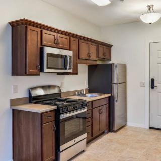 Modern kitchen with wooden cabinets and stainless steel appliances.