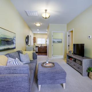 A cozy and well-decorated living room featuring a comfortable sofa, television, and stylish artwork.