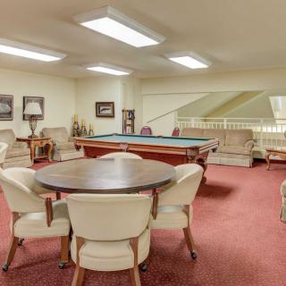 A cozy game room featuring a billiards table and comfortable seating options.