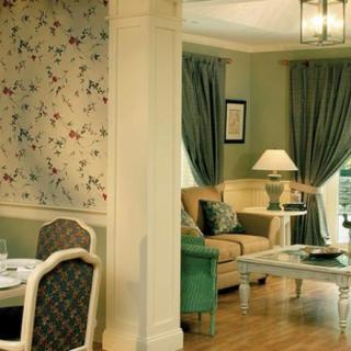 Elegant living room with classic decor and floral wallpaper.