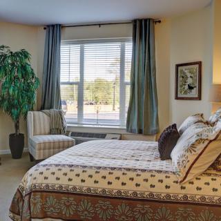 A cozy bedroom with a comfortable bed, large window, and stylish decor.