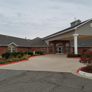 A welcoming entrance to a residential building surrounded by well-maintained landscaping.