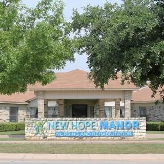 Exterior view of New Hope Manor, showcasing the entrance and landscaping.